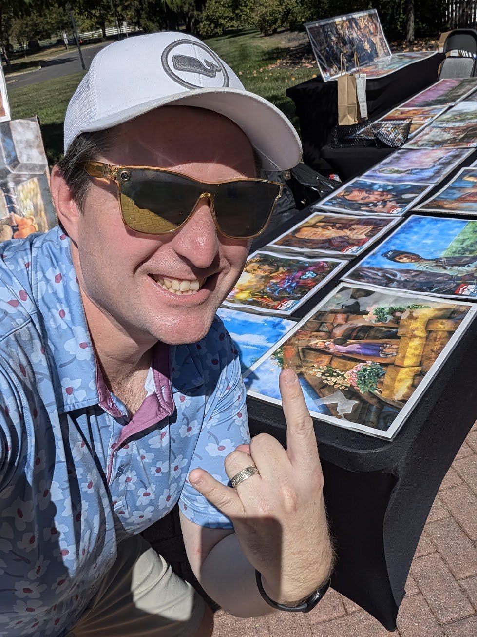 John Daly smiling beside an outdoor display of his movie-inspired artwork
